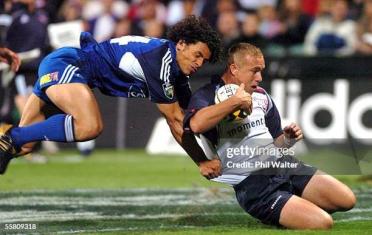 AUCKLAND, NEW ZEALAND - APRIL 09:  Blues Doug Howlett tackles Bulls Ettienne Botha in their Super 12 rugby match played at the North Harbour Stadium in Auckland, New Zealand, Friday, April 09th, 2004.  (Photo by Phil Walter/Getty Images)
