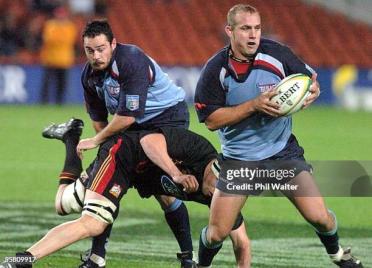 HAMILTON, NEW ZEALAND - APRIL 30:  Bulls Ettienne Botha is tackled by Chiefs Jono Ginnes in their Super 12 rugby match played at Waikato Stadium in Hamilton, New Zealand, Friday, April 30th, 2004. The Chiefs won 2422.  (Photo by Phil Walter/Getty Images)